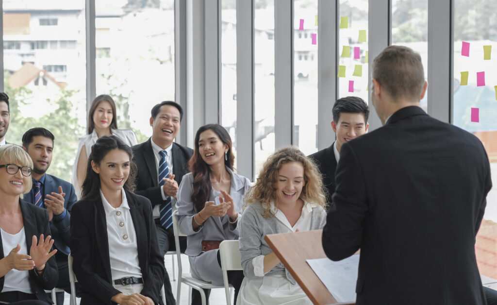 Diversity business audience group smiles and happy listening to male speaker giving a speech in corporate seminar event at conference room.